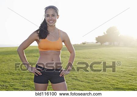 Stock Image - Hispanic woman smiling in field. Fotosearch