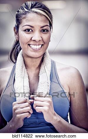 Stock Image - Hispanic woman smiling in gym. Fotosearch