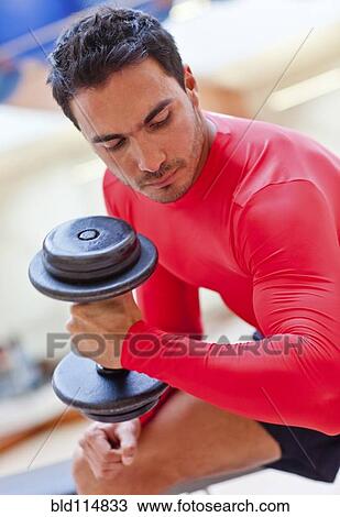 Stock Image - Hispanic woman smiling in gym. Fotosearch