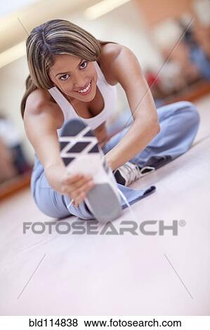 Hispanic woman stretching in gym View Large Photo Image Stock Photo - Hispanic woman stretching in gym. Fotosearch