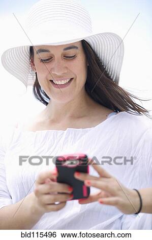 Hispanic woman using cell phone outdoors View Large Photo Image Stock Photograph - Hispanic woman using cell phone outdoors. Fotosearch