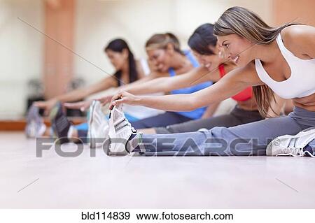 Stock Photo - Hispanic women stretching in gym. Fotosearch