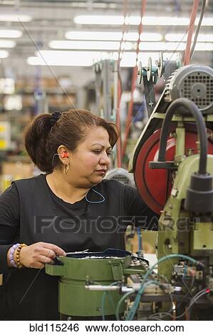 Hispanic worker operating machinery in textile factory View Large Photo Image Stock Photograph - Hispanic worker operating machinery in textile factory. Fotosearch