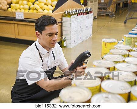 Stock Image - Hispanic worker scanning items in grocery store. Fotosearch