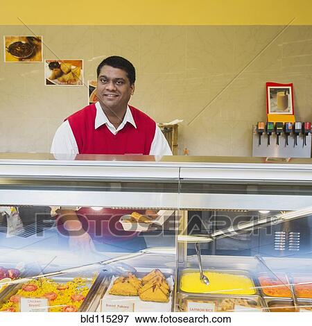 Stock Photo - Indian businessman behind restaurant counter. Fotosearch