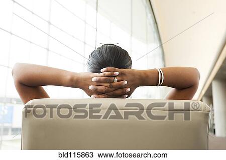 Stock Image - Indian businesswoman sitting in lobby area. Fotosearch