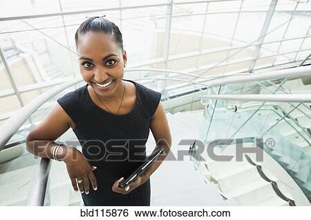 Stock Photograph - Indian businesswoman standing on staircase. Fotosearch