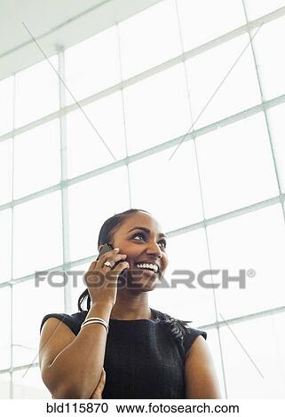 Stock Image - Indian businesswoman talking on cell phone. Fotosearch