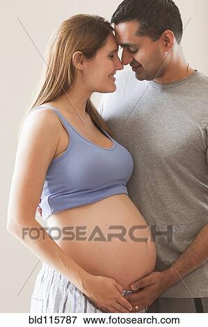 Stock Photo - Man holding pregnant woman's stomach. Fotosearch