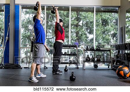 Stock Image - Men working out in gym. Fotosearch