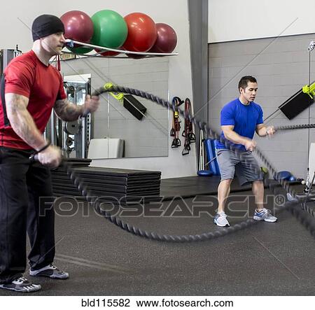 Stock Image - Men working out in gym. Fotosearch