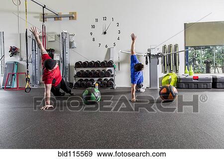 Stock Photo - Men working out in gym. Fotosearch