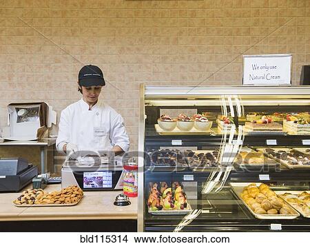 Picture - Middle Eastern woman working in bakery. Fotosearch