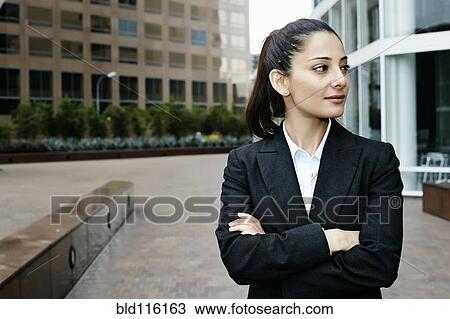 Stock Image - Mixed race businesswoman standing outdoors. Fotosearch
