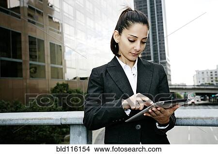 Picture - Mixed race businesswoman using tablet computer. Fotosearch