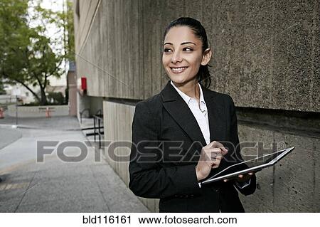 Stock Image - Mixed race businesswoman using tablet computer. Fotosearch