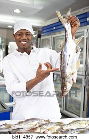 Mixed race grocer preparing fish in market View Large Photo Image Stock Photo - Mixed race grocer preparing fish in market. Fotosearch