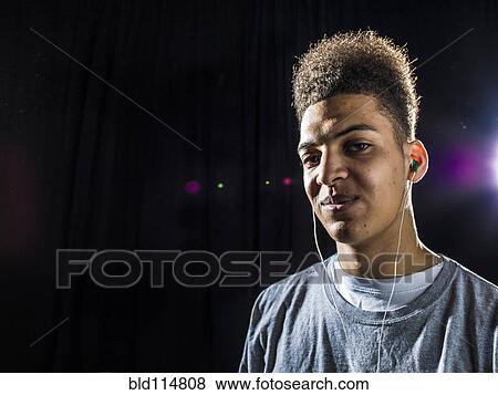 Mixed race man wearing earphones View Large Photo Image Stock Photo - Mixed race man wearing earphones. Fotosearch