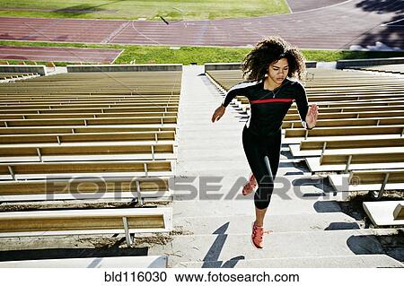Stock Image - Mixed race runner training in stadium. Fotosearch