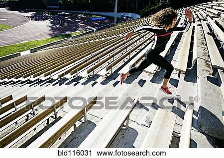 Stock Image - Mixed race runner training in stadium. Fotosearch