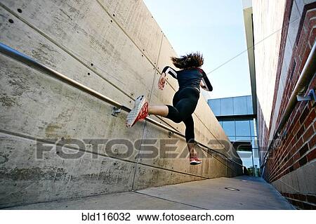 Stock Image - Mixed race runner training in stadium. Fotosearch