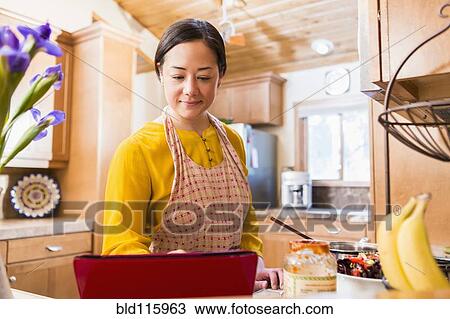 Mixed race woman cooking in kitchen View Large Photo Image Stock Image - Mixed race woman cooking in kitchen. Fotosearch