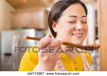 Mixed race woman cooking in kitchen View Large Photo Image Stock Photo - Mixed race woman cooking in kitchen. Fotosearch