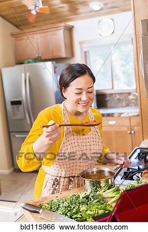 Mixed race woman cooking in kitchen View Large Photo Image Stock Photograph - Mixed race woman cooking in kitchen. Fotosearch