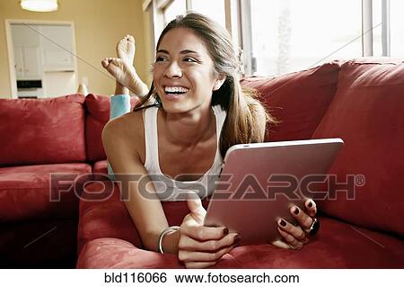 Stock Photograph - Mixed race woman using tablet computer. Fotosearch