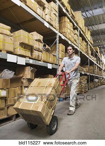 Mixed race worker carting boxes in textile factory View Large Photo Image Stock Photo - Mixed race worker carting boxes in textile factory. Fotosearch