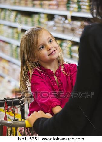 Stock Image - Mother and daughter shopping in grocery store. Fotosearch