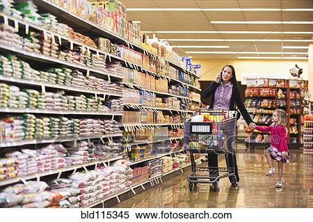 Stock Photography - Mother and daughter shopping in grocery store. Fotosearch