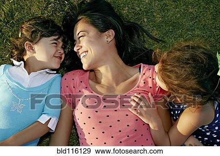Mother and daughters smiling in grass View Large Photo Image Stock Photo - Mother and daughters smiling in grass. Fotosearch