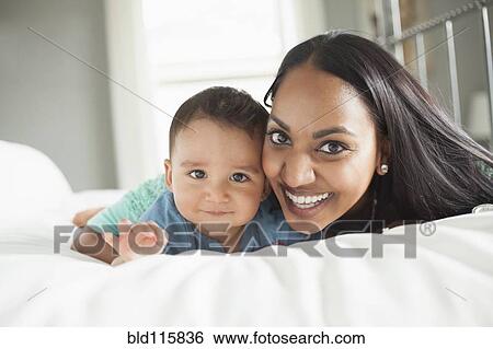 Stock Photograph - Mother and son laying on bed. Fotosearch