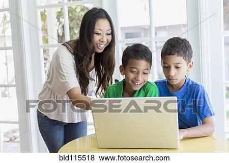Stock Photo - Mother and sons using laptop. Fotosearch