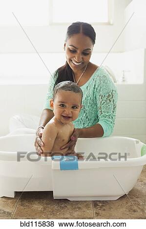 Mother bathing baby son in tub View Large Photo Image Stock Photo - Mother bathing baby son in tub. Fotosearch