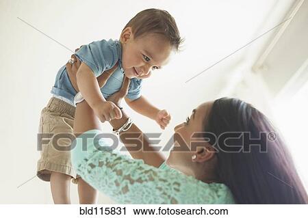 Stock Image - Mother playing with baby boy. Fotosearch