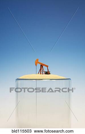 Stock Image - Oil pump on top of empty glass. Fotosearch