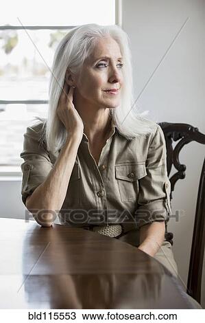 Older Caucasian woman sitting at table View Large Photo Image Stock Image - Older Caucasian woman sitting at table. Fotosearch