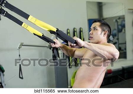 Stock Photography - Pacific Islander man working out in gym. Fotosearch