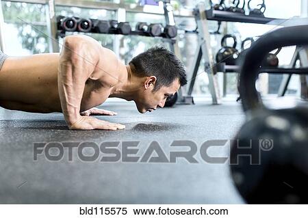 Stock Photography - Pacific Islander man working out in gym. Fotosearch