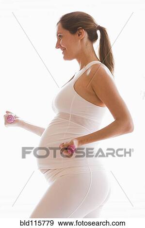 Stock Photo - Pregnant woman lifting weights. Fotosearch