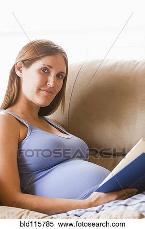 Pregnant woman reading on sofa View Large Photo Image Stock Photography - Pregnant woman reading on sofa. Fotosearch