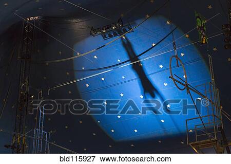 Stock Photo - Shadow of acrobat in spotlight on wall. Fotosearch