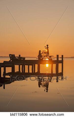 Silhouette of Caucasian children on wooden dock View Large Photo Image Stock Photograph - Silhouette of Caucasian children on wooden dock. Fotosearch