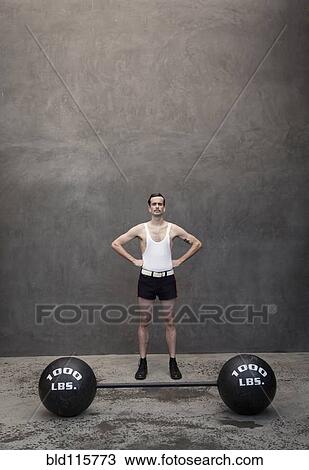 Skinny Caucasian weight lifter standing by weights View Large Photo Image Stock Image - Skinny Caucasian weight lifter standing by weights. Fotosearch