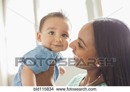 Picture - Smiling mother holding son. Fotosearch