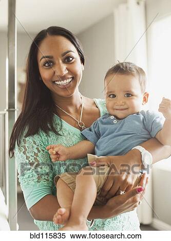 Stock Photography - Smiling mother holding son. Fotosearch