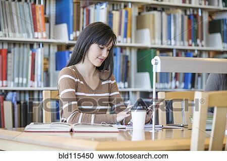 Student working at desk in library View Large Photo Image Stock Image - Student working at desk in library. Fotosearch