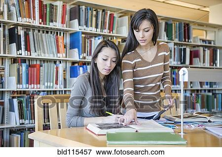 Stock Photo - Students working at desk in library. Fotosearch